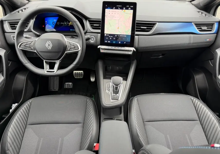 Vue intérieure avant du Renault Symbioz 2026 gris Rafale, avec tableau de bord numérique et écran tactile central vertical.