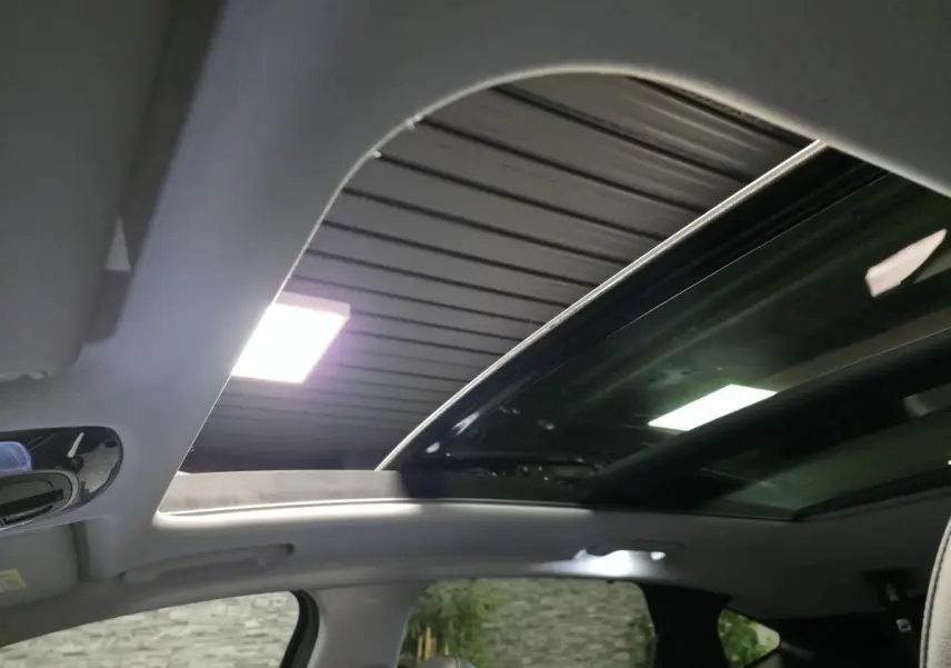 Toit ouvrant panoramique ouvert sur l'intérieur gris clair du Hyundai Tucson 2020, vue vers le ciel depuis l'habitacle.