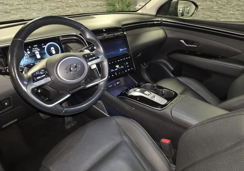 Vue intérieure côté conducteur du Hyundai Tucson 2020, avec tableau de bord numérique et sellerie cuir noire.