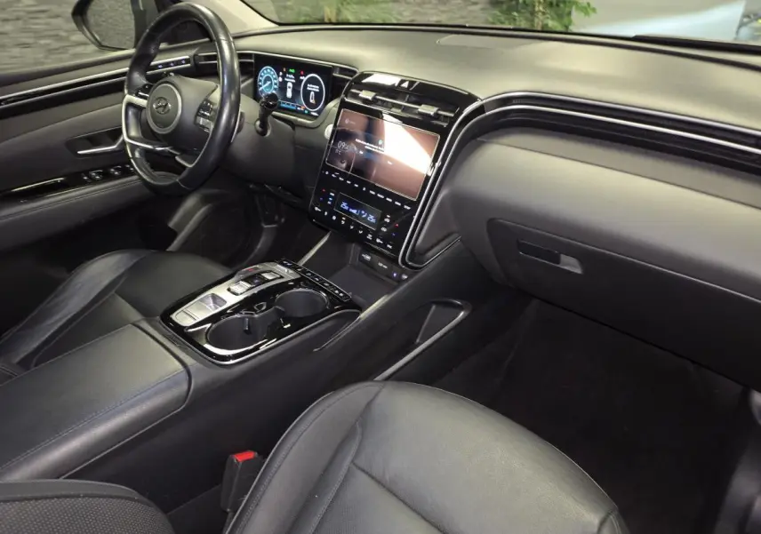 Vue intérieure côté passager du Hyundai Tucson gris 2020, mettant en valeur le tableau de bord numérique et la console centrale moderne.