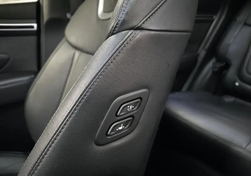 Détail des commandes de réglage sur le côté du siège avant en cuir noir du Hyundai Tucson gris.