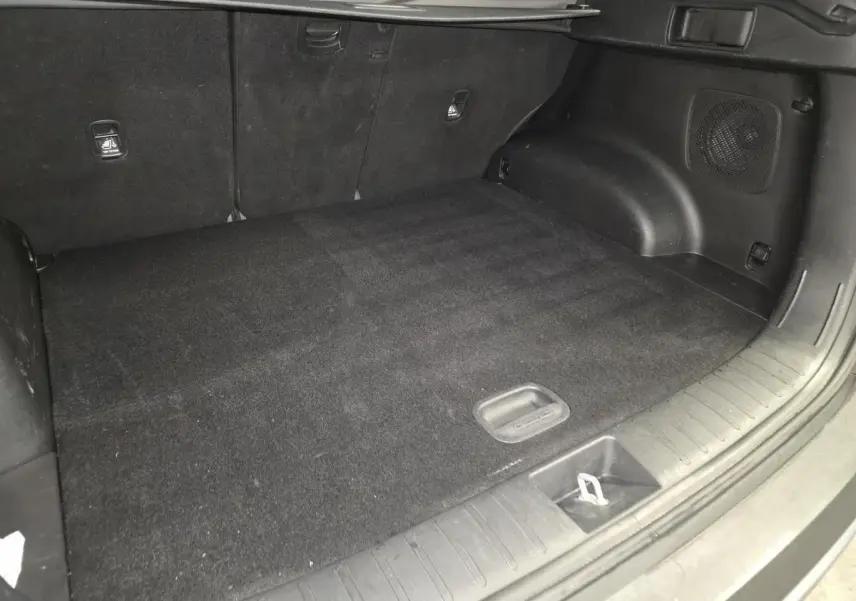 Coffre spacieux vu de face, intérieur noir avec tapis et habillage en tissu du Hyundai Tucson gris 2020.