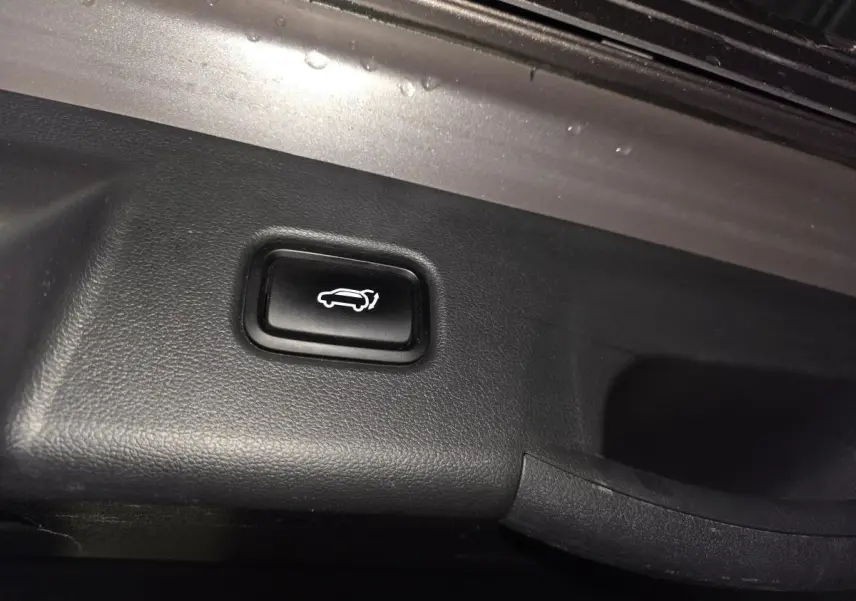 Bouton d'ouverture électrique du hayon dans le coffre du Hyundai Tucson gris 2020, version Executive.