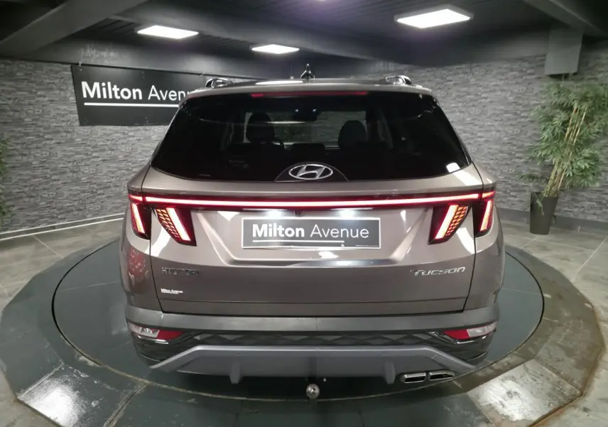 Vue arrière d'un Hyundai Tucson gris métallisé 2020 avec feux arrière LED en bandeau lumineux et double sortie d'échappement.