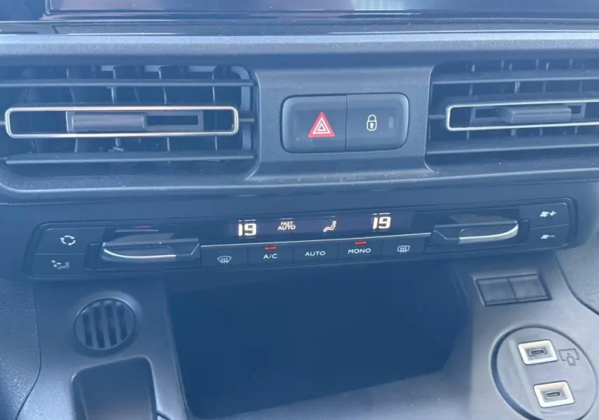 Vue rapprochée de la console centrale du Citroën Berlingo 2024, montrant la climatisation automatique et les ports USB.