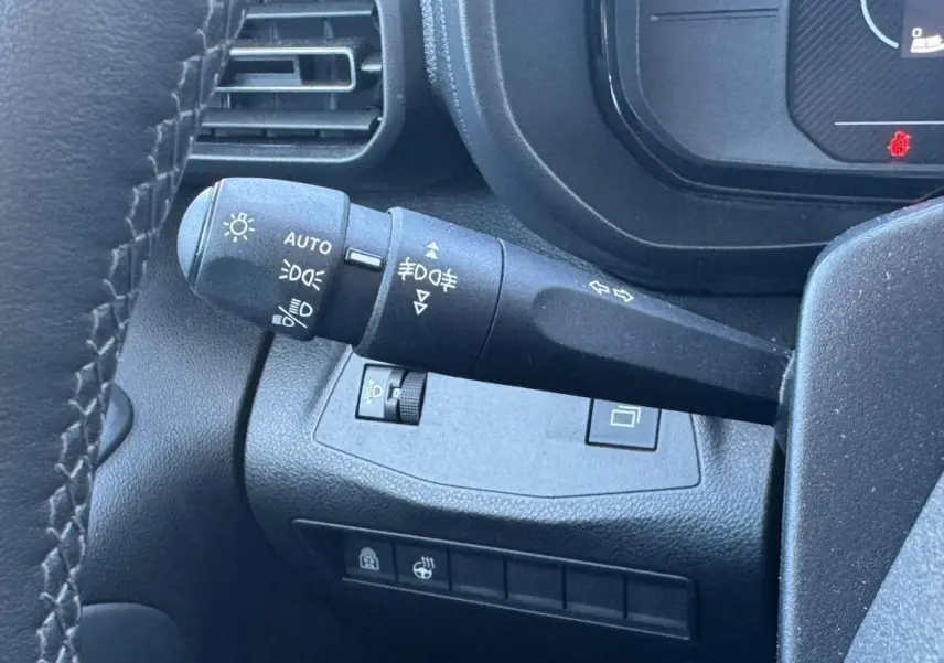Gros plan sur la manette de commande des feux et clignotants du tableau de bord du Citroën Berlingo 2024.