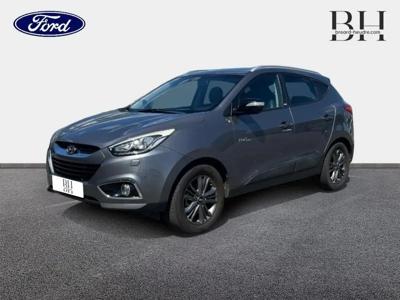 Vue 3/4 avant droit d'un Hyundai ix35 1.6 GDI Pack Confort BlueDrive 2014 en gris Steel Grey avec jantes alu.