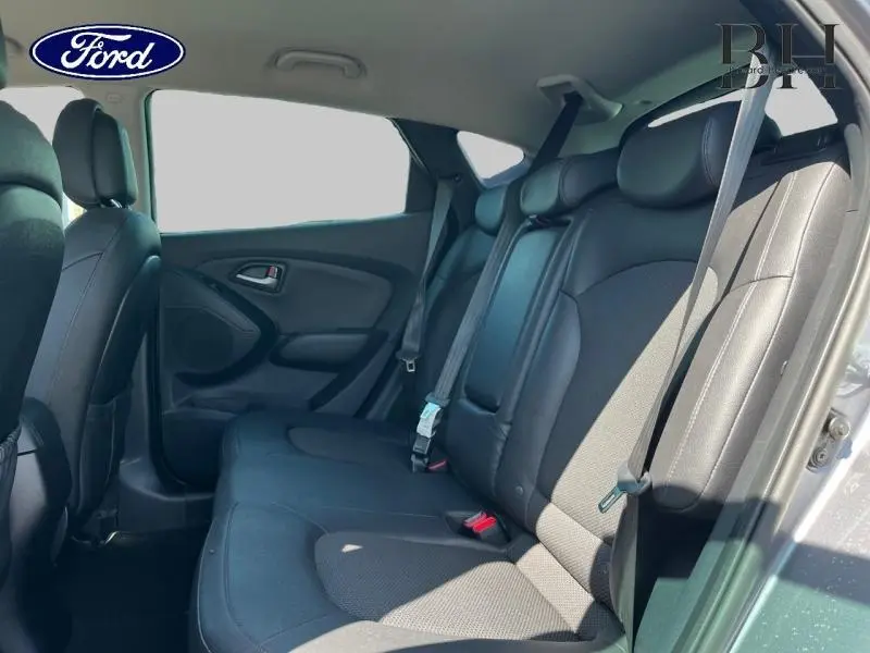 Vue intérieure côté droit de la banquette arrière en tissu noir du Hyundai ix35 Steel Grey, avec ceintures de sécurité visibles.