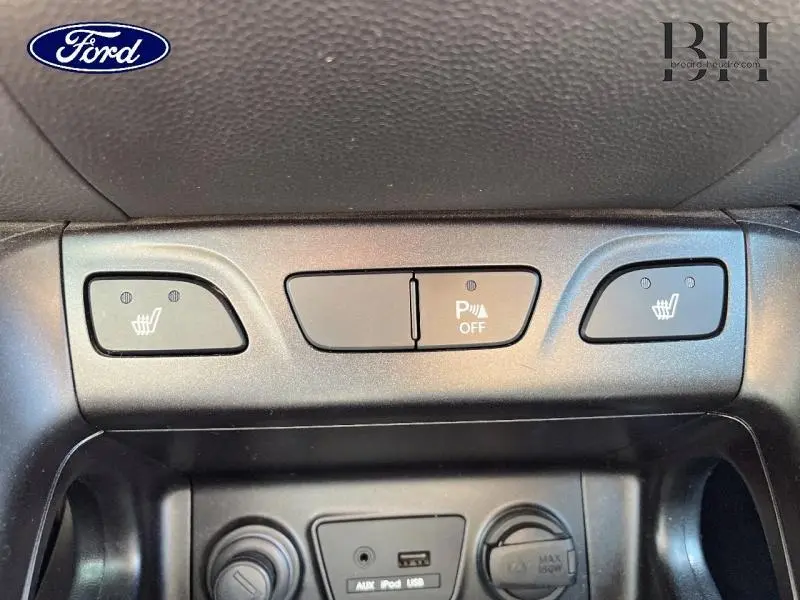 Gros plan sur les commandes de sièges chauffants et désactivation du radar de recul dans un Hyundai ix35 gris acier de 2014.
