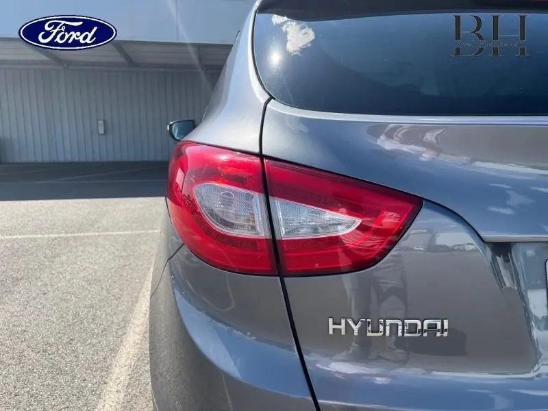 Gros plan sur le feu arrière gauche d’un Hyundai ix35 2014 gris acier avec logo Hyundai visible sur le hayon.