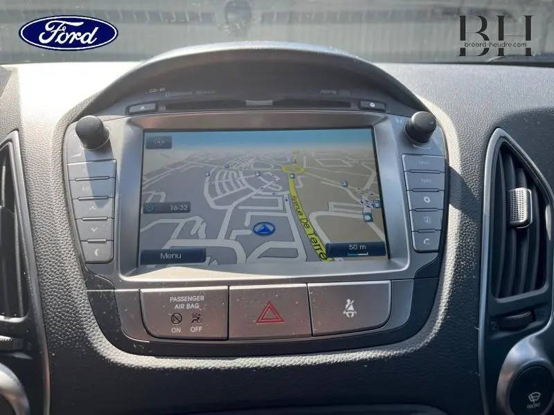 Tableau de bord avec écran GPS central d'une Hyundai ix35 gris acier, vue rapprochée de la console multimédia.