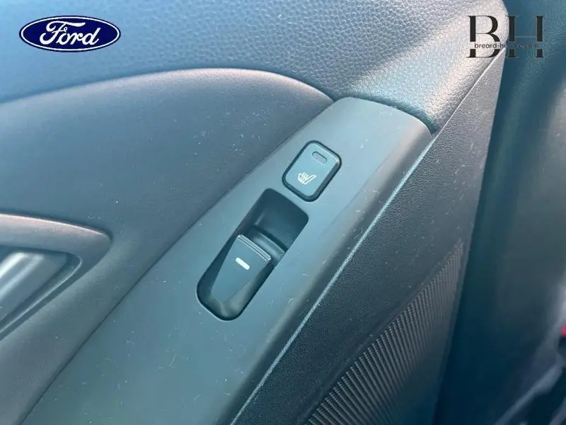 Gros plan sur la commande de lève-vitre et bouton de siège chauffant côté conducteur, intérieur noir du Hyundai ix35.
