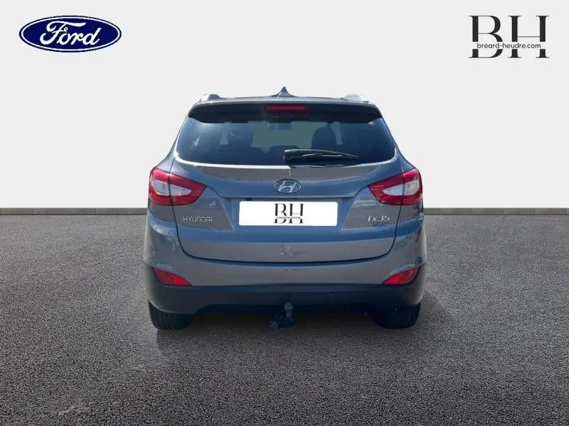 Vue arrière d'un Hyundai ix35 gris acier 2014 avec feux arrière rouges et attelage visible.
