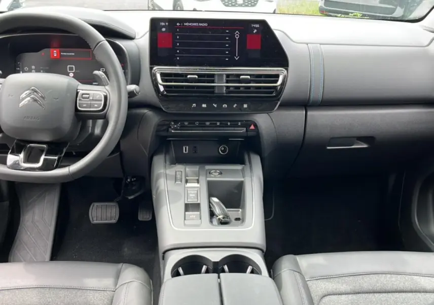 Vue intérieure avant du Citroën C5 Aircross 2025, tableau de bord et console centrale avec écran tactile et volant multifonction.