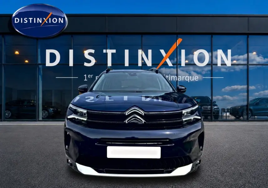 Vue frontale d'un Citroën C5 Aircross bleu eclipse avec calandre noire et barres de toit visibles.