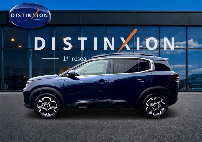 Profil côté gauche du Citroën C5 Aircross bleu eclipse 2025 avec jantes alu et barres de toit visibles.