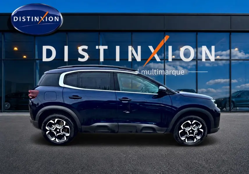 Vue latérale droite d'un Citroën C5 Aircross bleu eclipse 2025 avec jantes alu et barres de toit visibles.