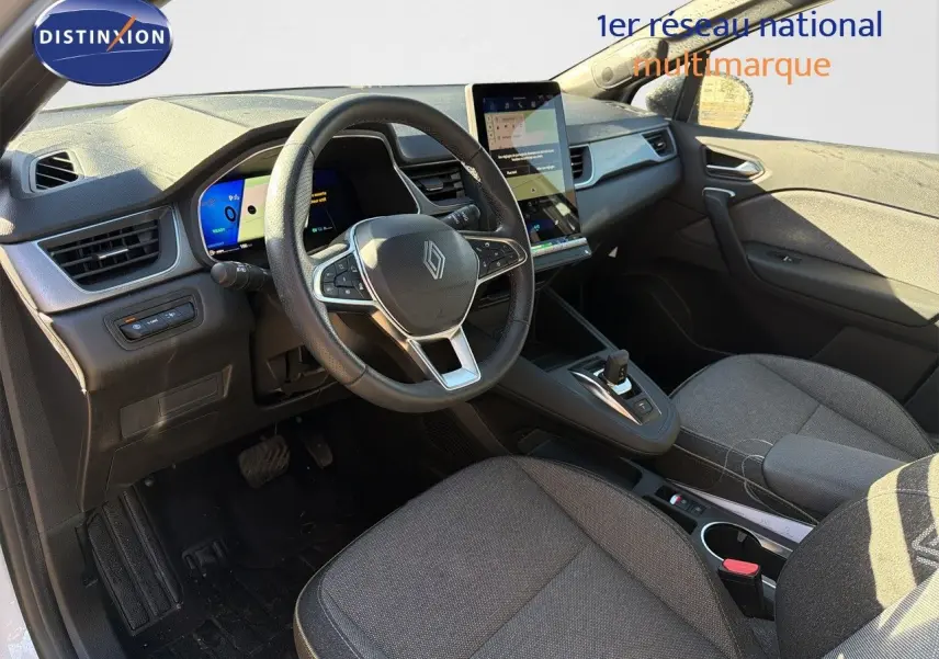 Vue intérieure avant droite du Renault Symbioz 2025, volant cuir, tableau de bord numérique et écran tactile vertical.