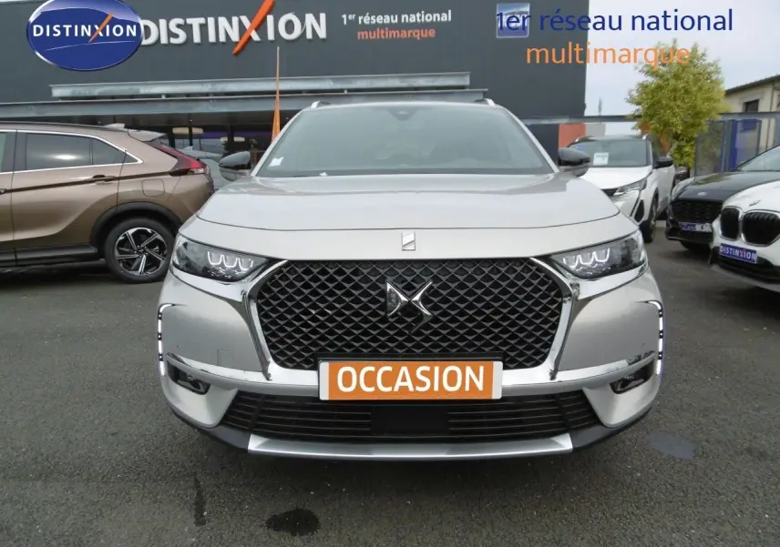 Vue frontale d'un DS7 Crossback hybride rechargeable Crystal Pearl avec calandre noire et feux LED distinctifs.