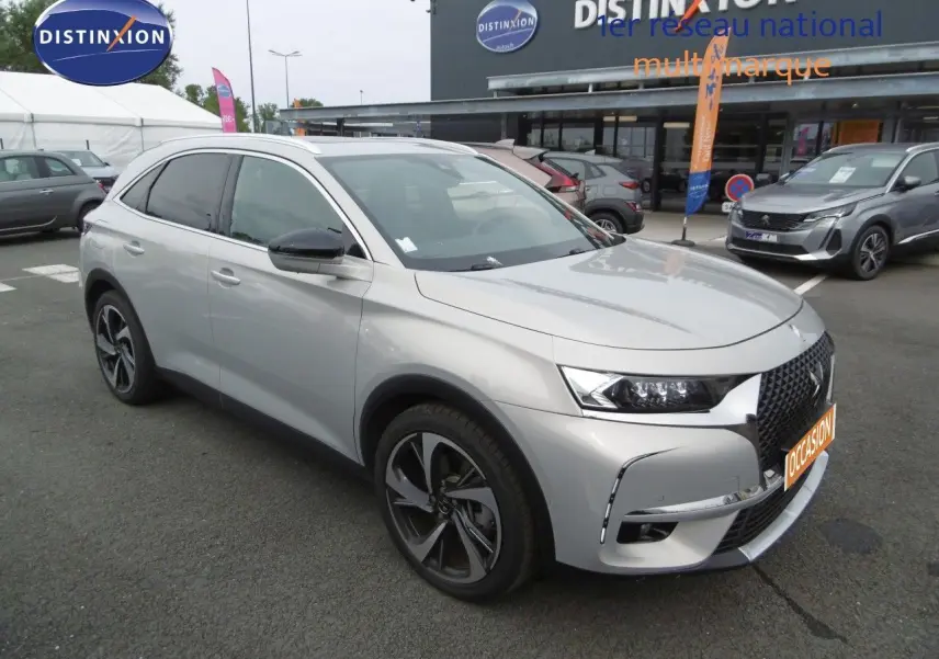 DS7 Crossback hybride rechargeable Crystal Pearl en 3/4 avant droit, avec jantes alliage et calandre distinctive.