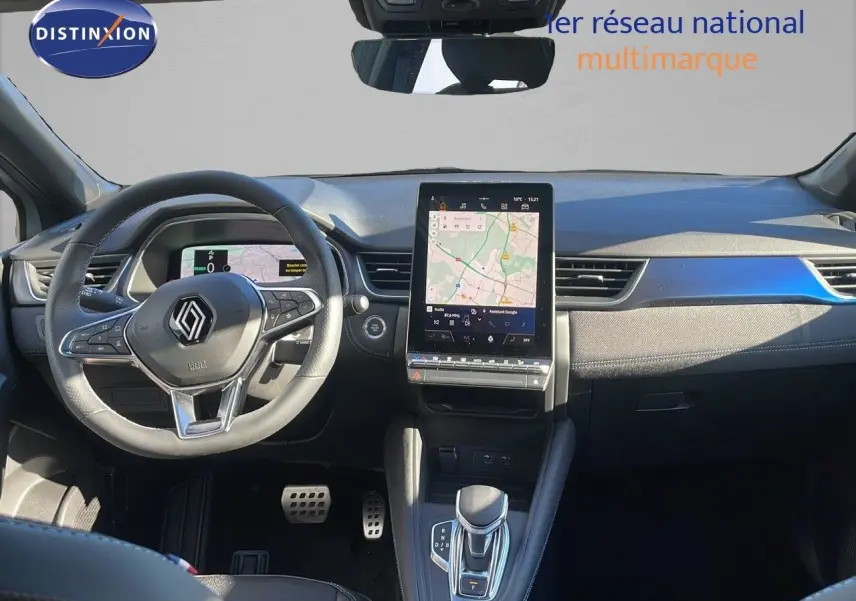 Vue intérieure frontale du tableau de bord du Renault Captur E-Tech hybride, avec écran tactile central et volant multifonction noir.