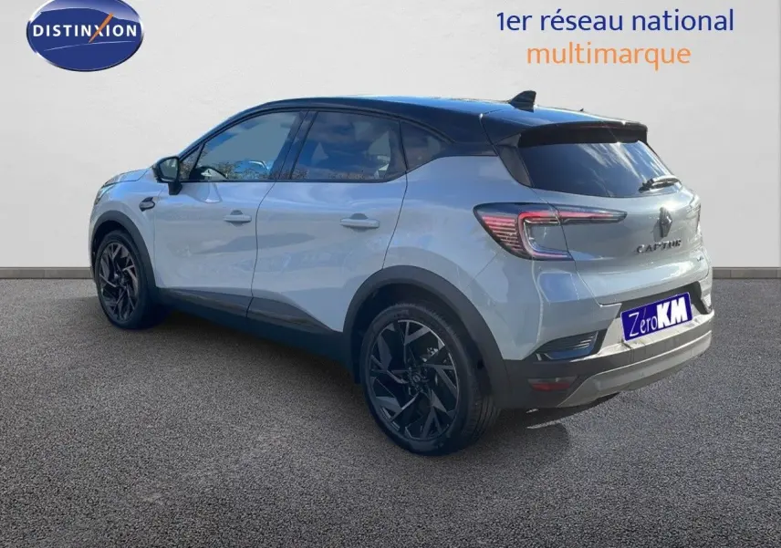 Vue 3/4 arrière droite d'un Renault Captur E-Tech hybride gris Rafale avec toit noir et jantes noires.