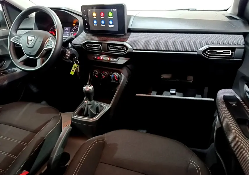 Vue intérieure avant droite du tableau de bord et volant cuir synthétique de la Dacia Sandero Confort TCe 90 2022.