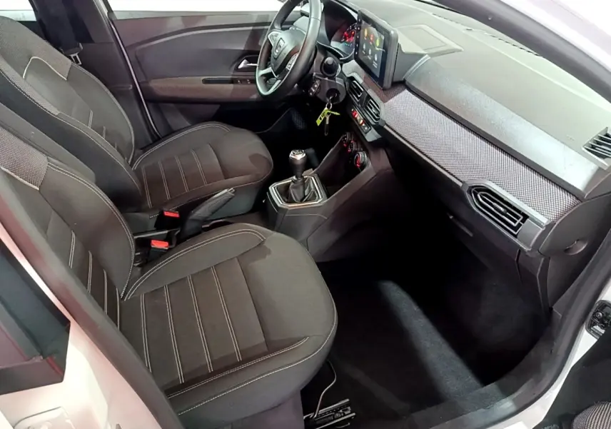Vue intérieure côté passager de la Dacia Sandero Confort TCe 90 2022, sièges noirs et tableau de bord avec écran tactile.