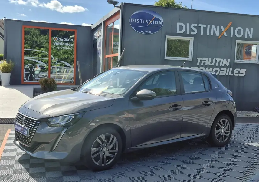 PEUGEOT 208 gris foncé en vue 3/4 avant droit, avec calandre distinctive et jantes alliage 16 pouces.