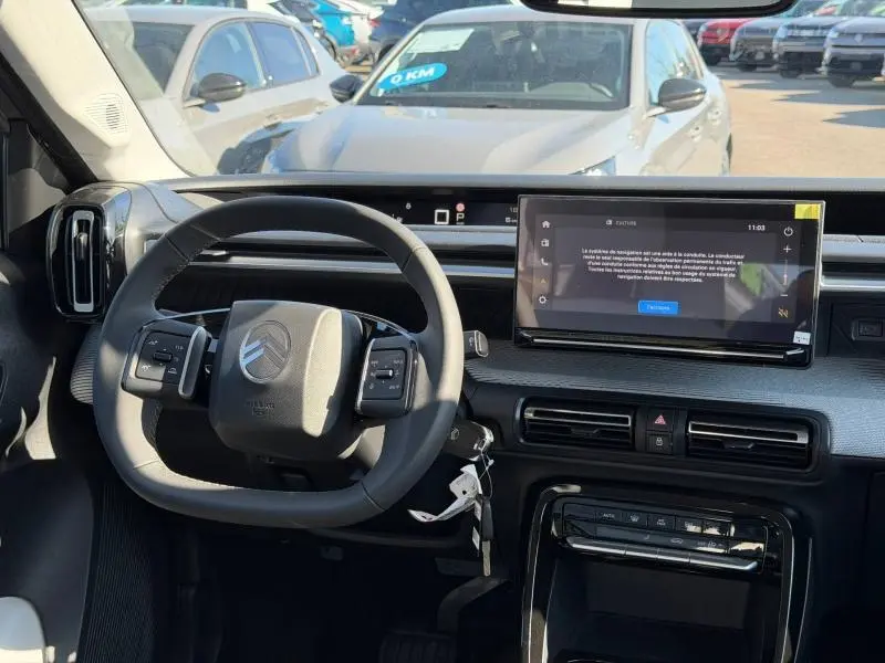 Vue intérieure du tableau de bord et volant du Citroën C3 Aircross 2026, avec écran tactile et commandes au volant.