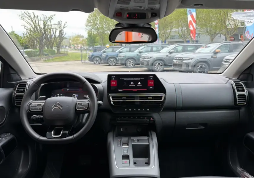Vue intérieure de face du tableau de bord du Citroën C5 Aircross Hybrid 145 gris platinium avec écran tactile et volant multifonctions.
