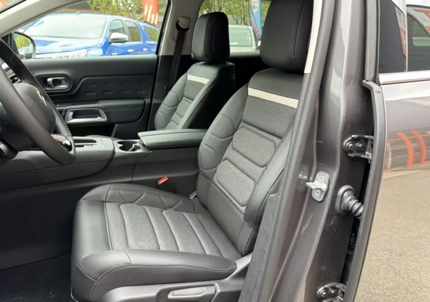 Vue intérieure côté conducteur du Citroën C5 Aircross Hybrid gris platinium, mettant en valeur les sièges Advanced Comfort et l'accoudoir central.