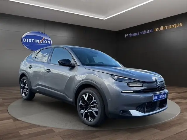 Vue 3/4 avant d'une Citroën C4 hybride gris clair, avec jantes noires et détails noirs contrastants.