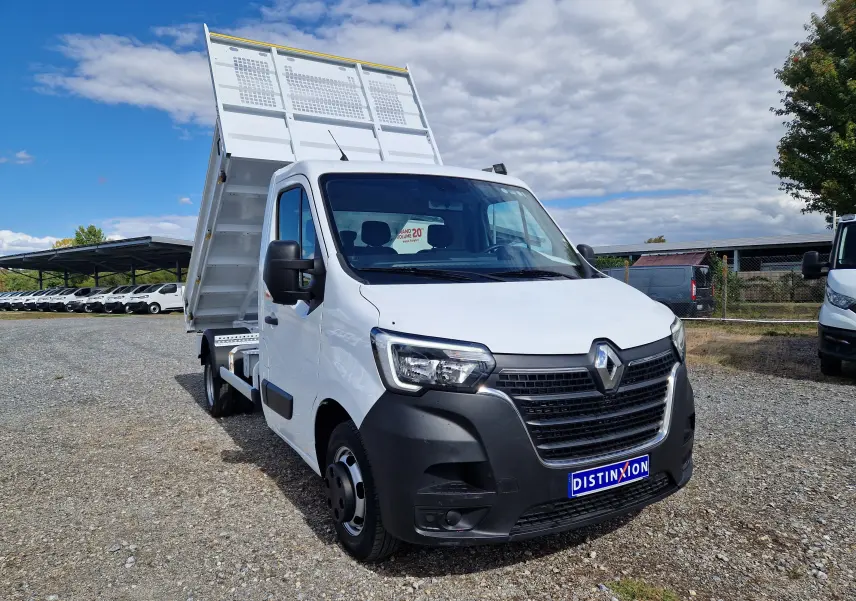 Renault Master Châssis cabine blanc en 3/4 avant droit avec benne relevée et roues jumelées visibles.