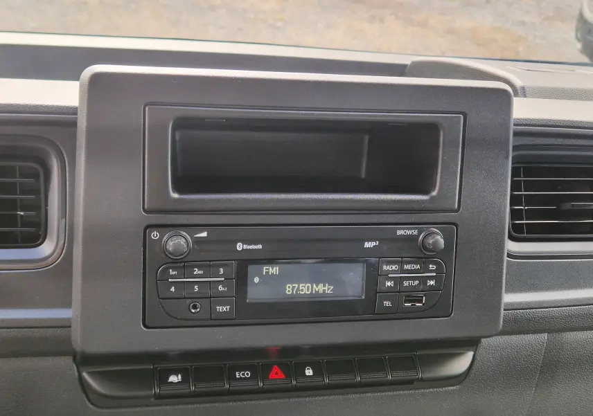 Vue rapprochée du tableau de bord noir du Renault Master Châssis Cabine 2024, avec radio et commandes centrales visibles.