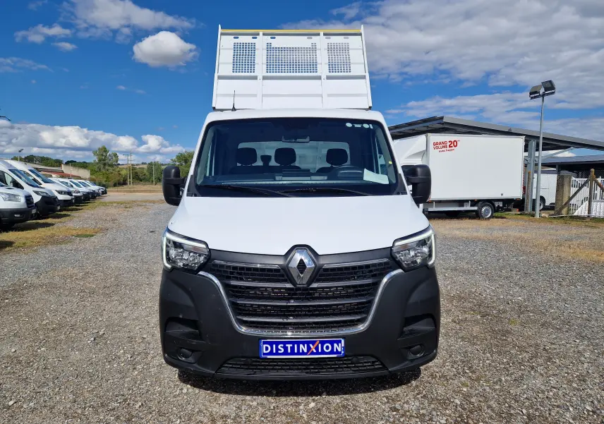 Vue avant d’un Renault Master Châssis Cabine blanc avec benne haute, calandre noire et plaque Distinxion visible.