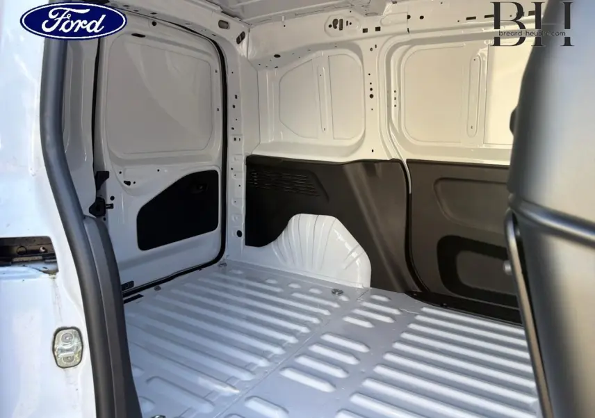 Vue intérieure arrière du coffre blanc Icy du Peugeot Partner 2025, montrant la cloison pleine et les parois métalliques.