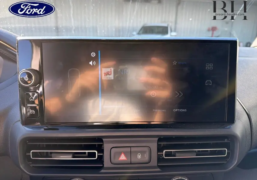 Écran tactile central du tableau de bord d’un Peugeot Partner blanc Icy, vue rapprochée intérieure.
