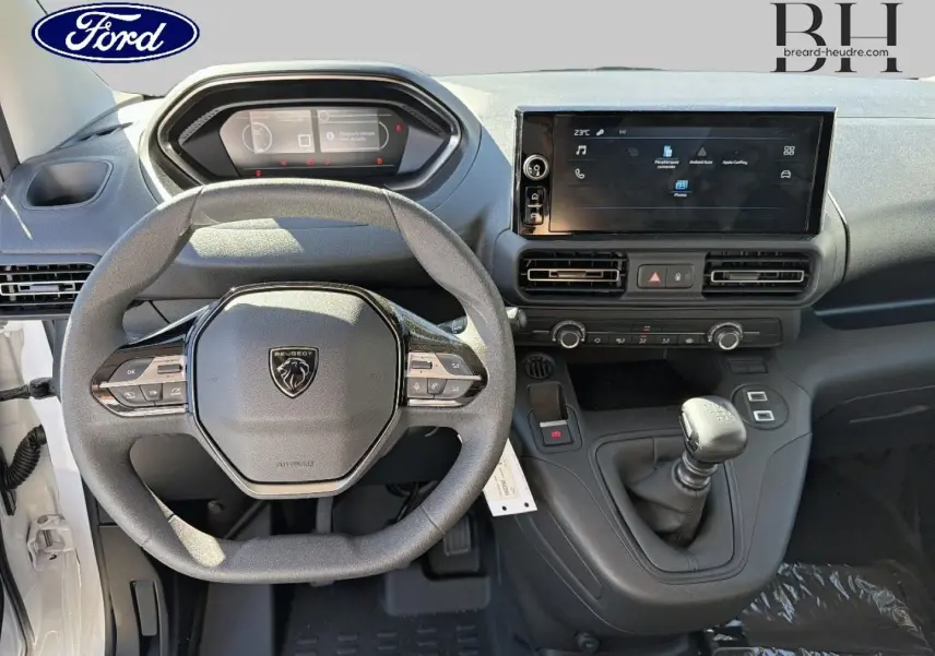 Vue intérieure frontale du tableau de bord du Peugeot Partner 2025 avec volant multifonction et écran tactile central.