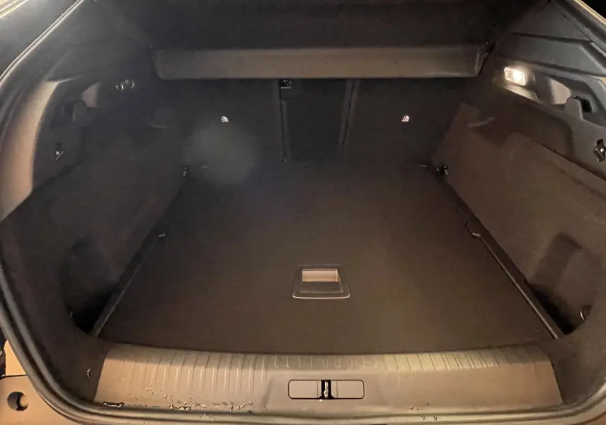 Coffre ouvert noir du Peugeot 3008 NV Hybrid 136 E-DCS6 Allure, vue intérieure spacieuse et éclairée.