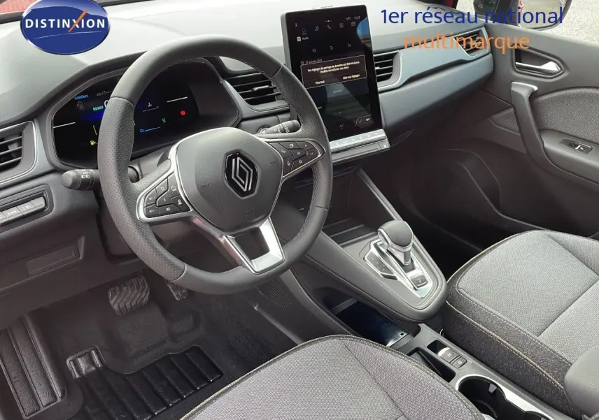 Intérieur du Renault Captur E-Tech hybride 2025, vue du poste de conduite avec volant multifonction et écran tactile central.