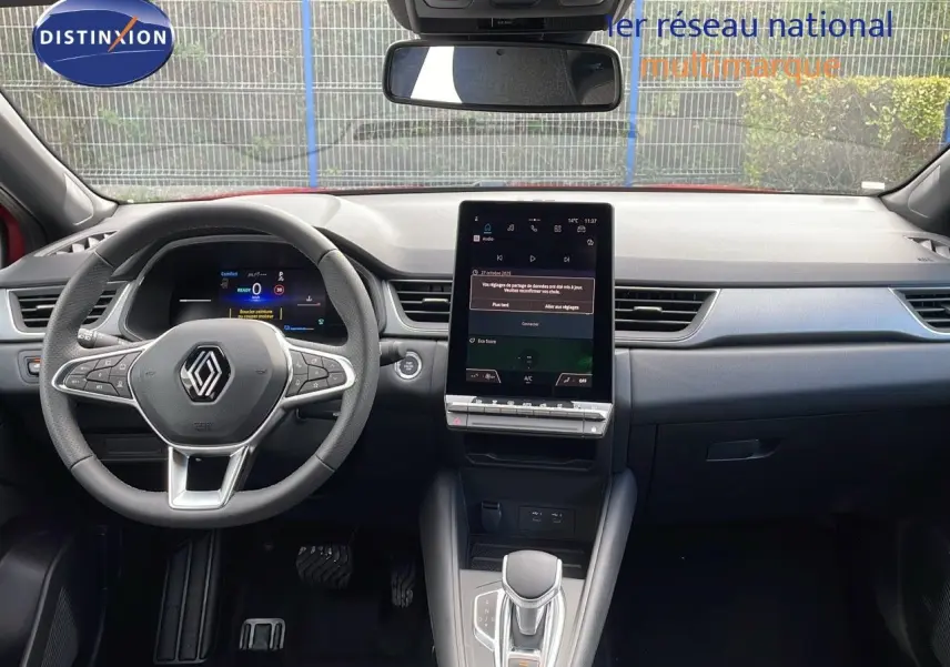 Intérieur du Renault Captur E-Tech hybride 2025, vue frontale du tableau de bord avec écran tactile vertical et volant multifonction.