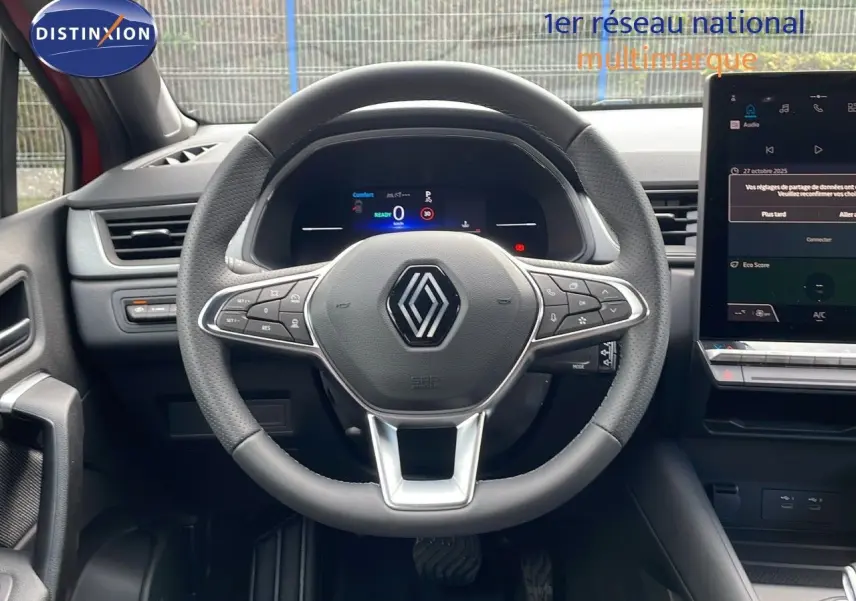Vue centrée sur le volant du Renault Captur E-Tech hybride 2025, avec tableau de bord numérique et écran tactile.