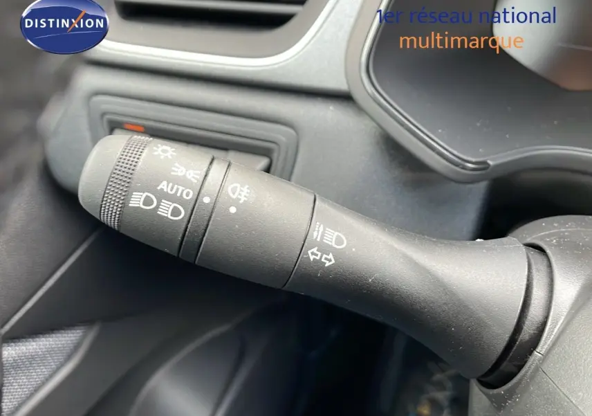 Gros plan sur la commande des feux et clignotants du Renault Captur E-Tech hybride 2025, intérieur noir.