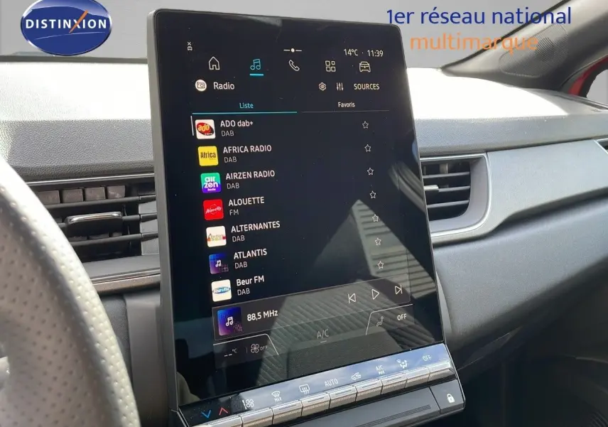 Vue intérieure du tableau de bord du Renault Captur E-Tech rouge, mettant en valeur l'écran tactile central.