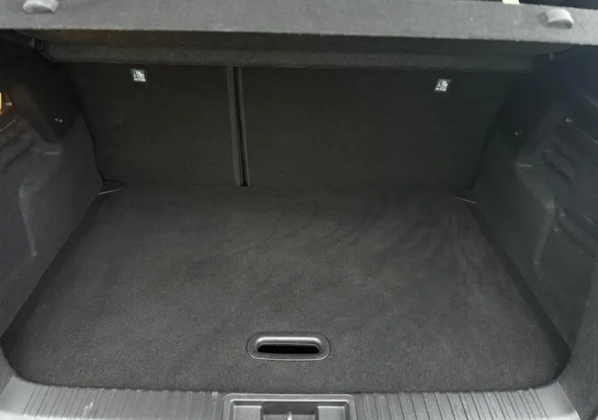 Vue intérieure du coffre spacieux et plat du Renault Captur 2025 gris Cassiopée avec finition noire.