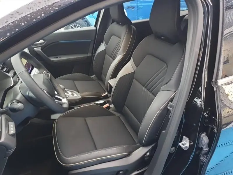 Vue intérieure côté gauche des sièges avant noirs avec surpiqûres blanches du Renault Symbioz 2025, porte ouverte.