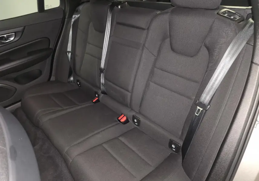 Vue intérieure sur la banquette arrière textile noire du Volvo V60 gris, avec ceintures de sécurité et ancrages Isofix visibles.