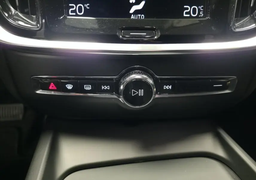 Gros plan sur la console centrale du Volvo V60 2021, boutons de commande audio et climatisation affichant 20°C.