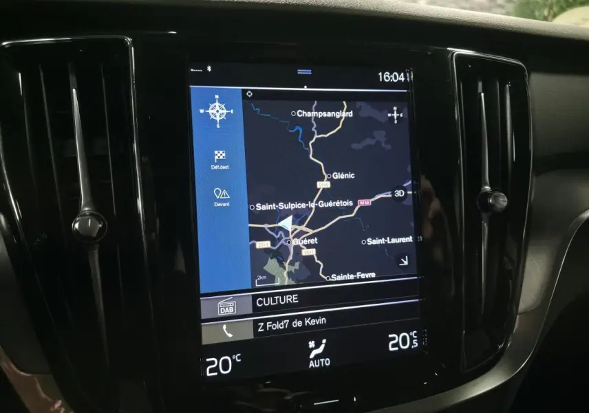 Vue rapprochée de l'écran tactile multimédia central du tableau de bord de la Volvo V60 gris, affichant la navigation GPS.
